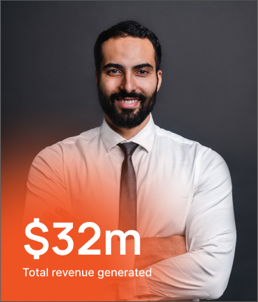A man in a white shirt and tie stands with arms crossed, smiling confidently. Text overlay reads "$32m Total revenue generated" on an orange gradient at the bottom left corner.